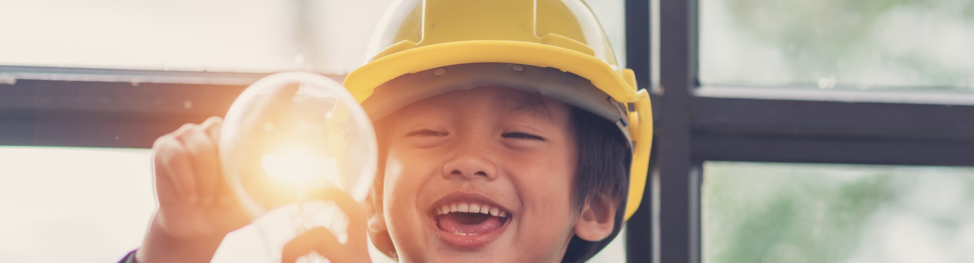 Smiling child holding a lightbulb