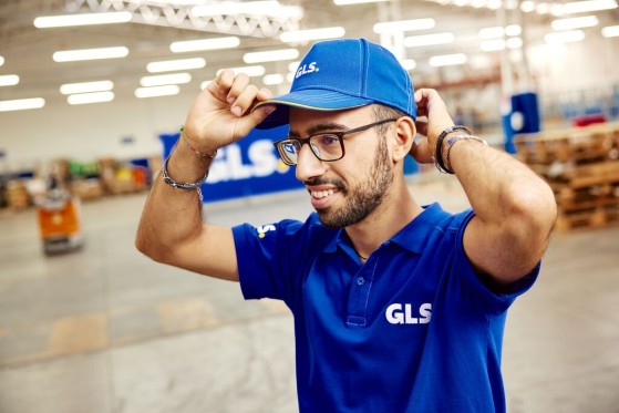 A GLS depot employee adjusts his blue cap