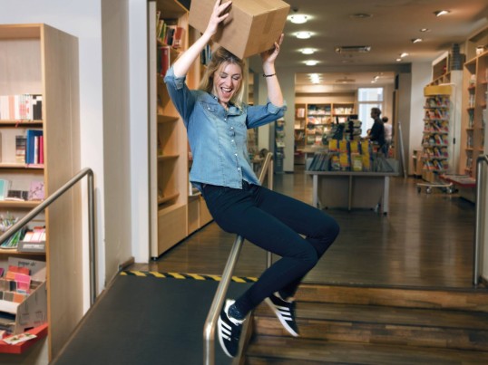 A man jumps in the air while holding a parcel