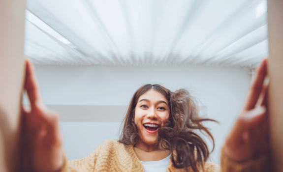 Dziewczyna otwiera paczkę od kuriera