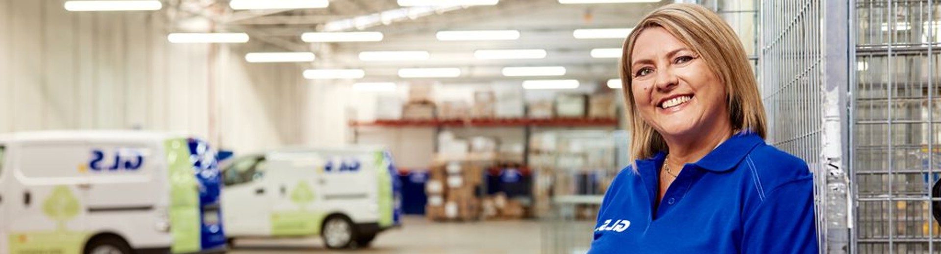  A GLS woman stands smiling in a GLS depot