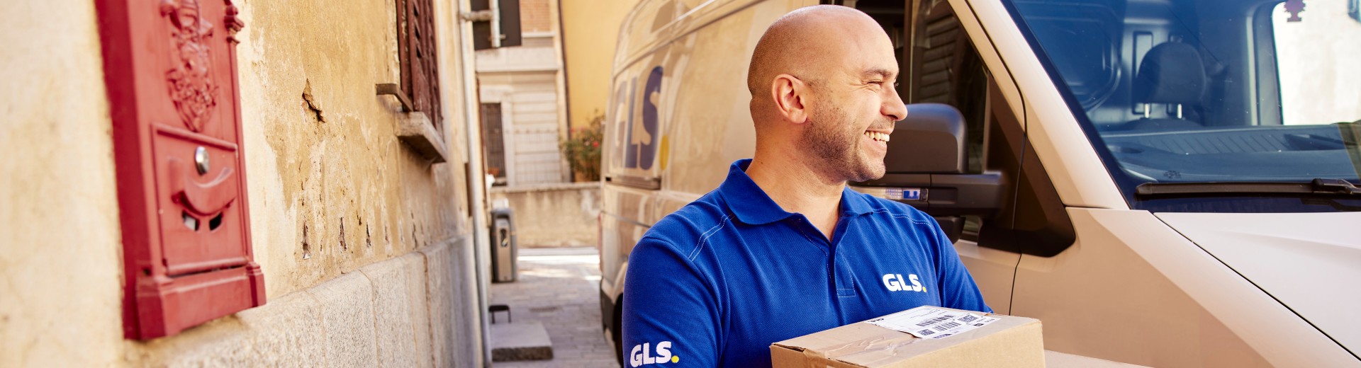 curier GLS în fața mașinii de livrare
